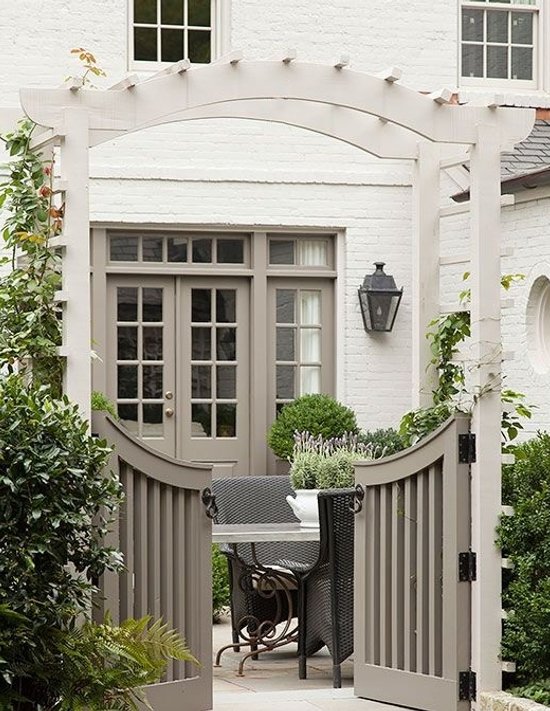 Arched white pergola gate framing a garden patio