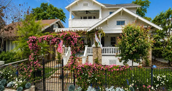 Designed front-yard rose garden with an entry gate and layered flower beds