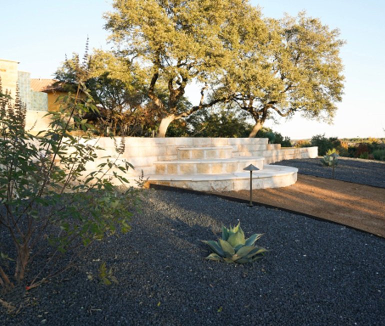 Landscaped Houston yard with stone steps and gravel drainage beds by Strong Landscaping