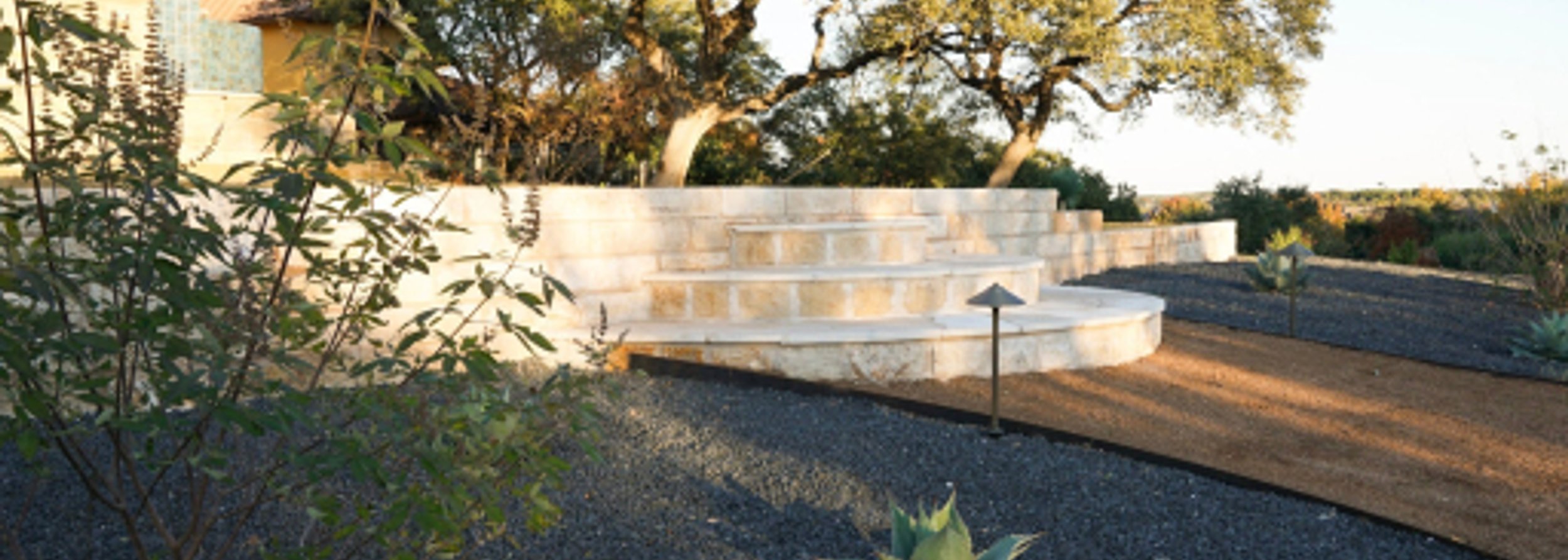 Landscaped Houston yard with stone steps and gravel drainage beds by Strong Landscaping