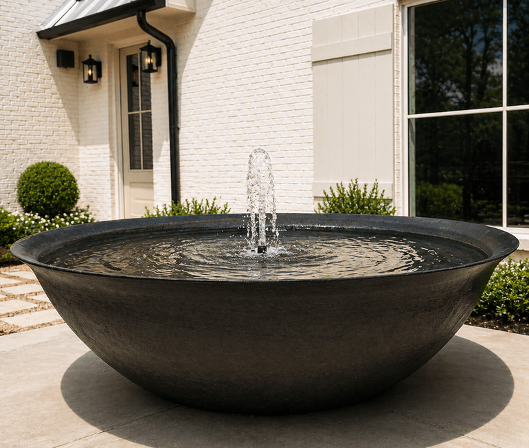 Stone bowl fountain water feature in an entry courtyard by Strong Landscaping in Houston