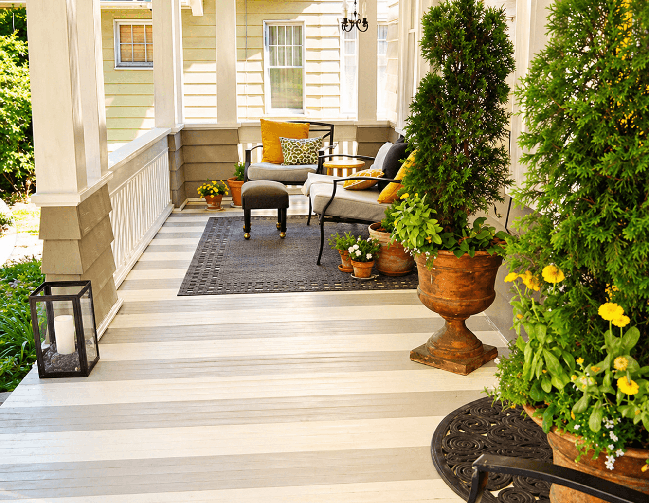 Covered front porch with planters and outdoor seating by Strong Landscaping