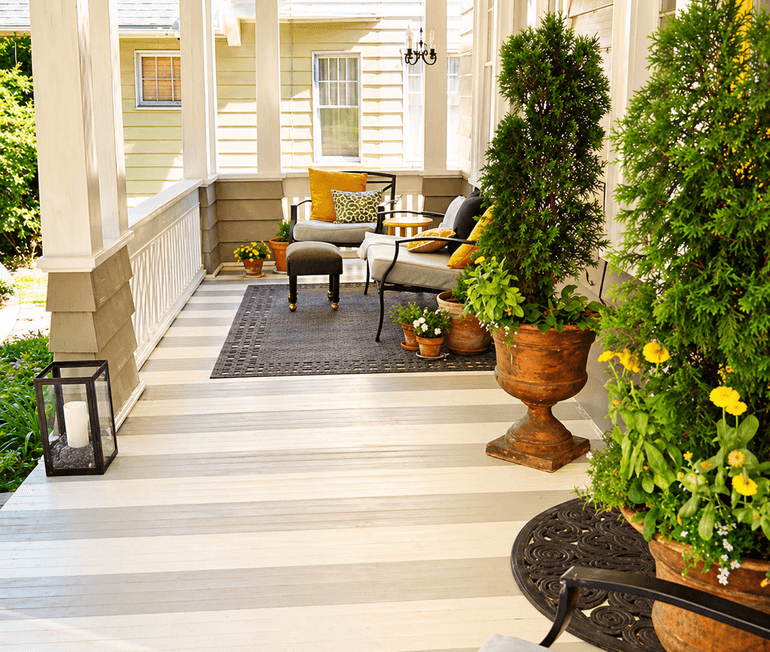Covered porch structure with planters and built-in outdoor seating built by Strong Landscaping