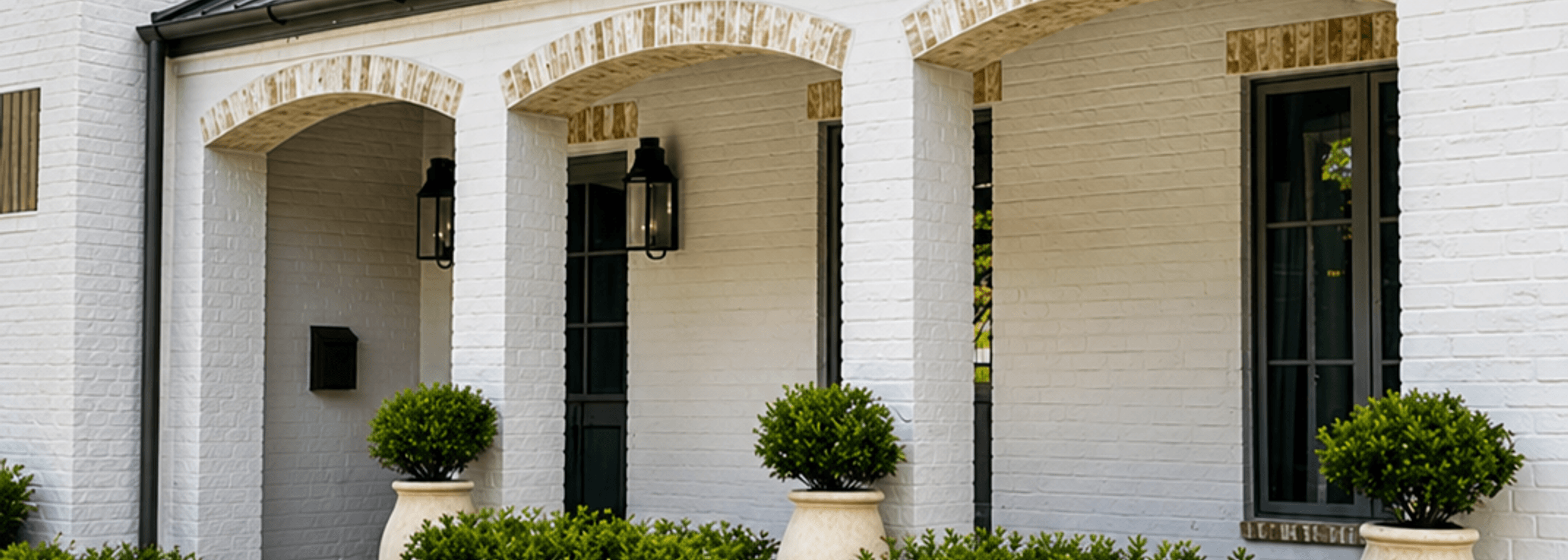 Stone paver walkway leading to a front porch with boxwood landscaping built by Strong Landscaping in Houston
