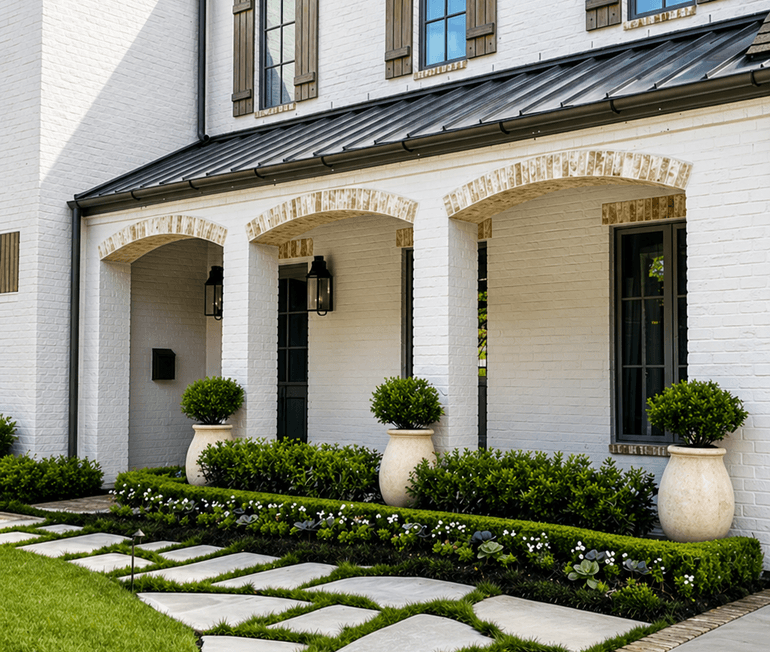 Stone paver walkway leading to a front porch with boxwood landscaping by Strong Landscaping in Houston