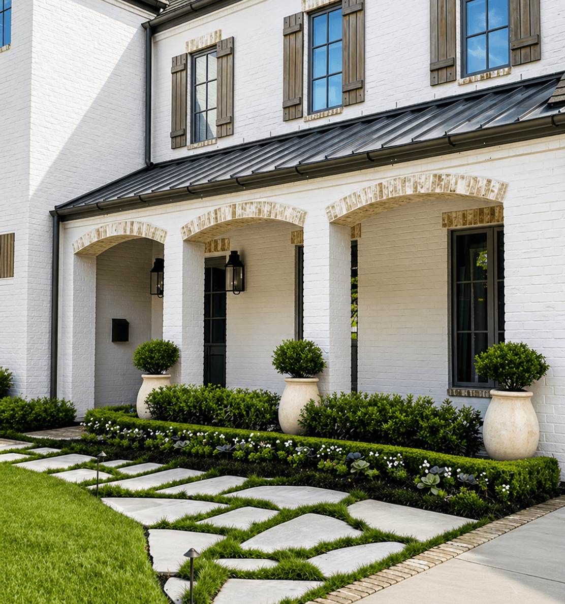 Front porch stone walkway framed by boxwoods and layered planting beds, built by Strong Landscaping in Houston