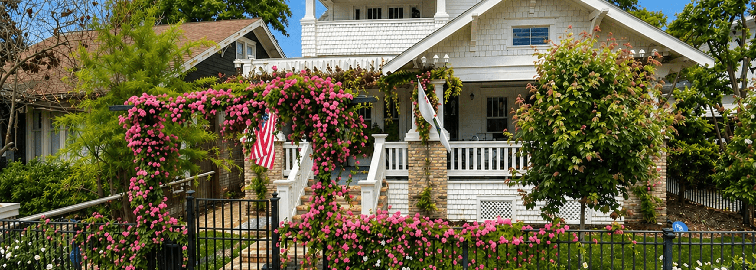 Designed front yard with a rose garden, entry gate, and layered flower beds by Strong Landscaping in Houston, TX