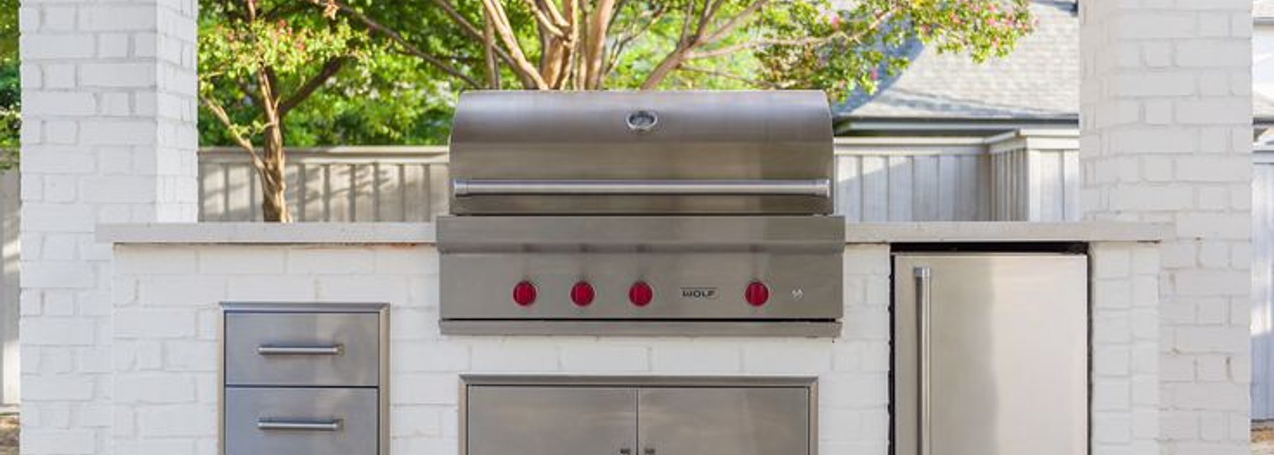 Outdoor kitchen with a built-in grill and patio built by Strong Landscaping in Westchase, Houston, TX