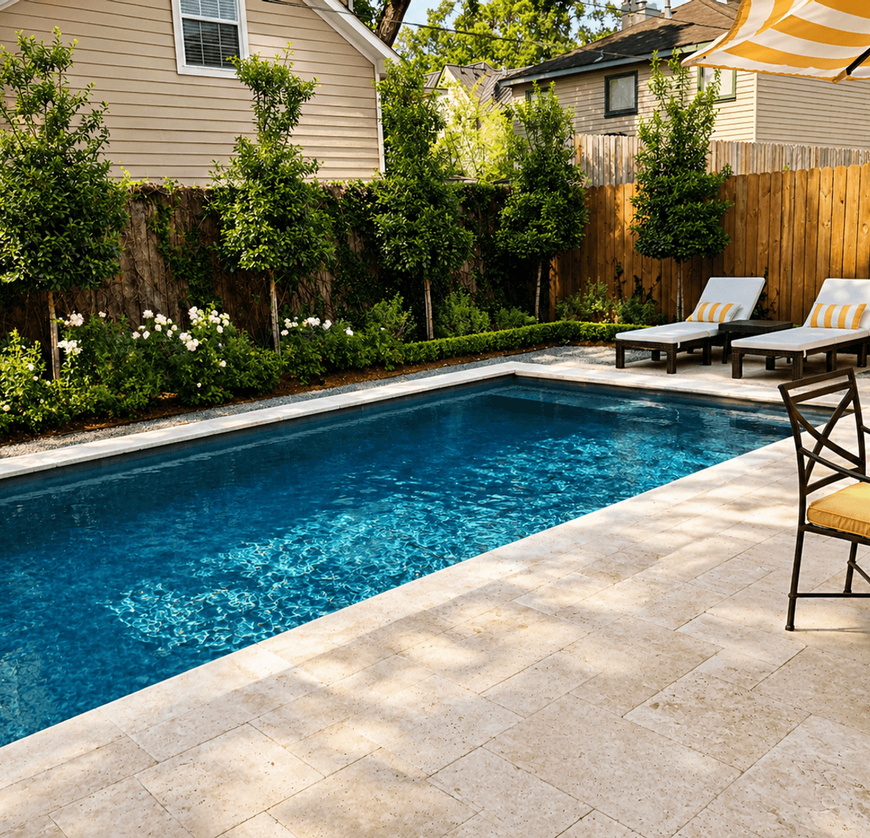 Pool patio with lounge chairs and lush landscaping, built by Strong Landscaping in Memorial, TX