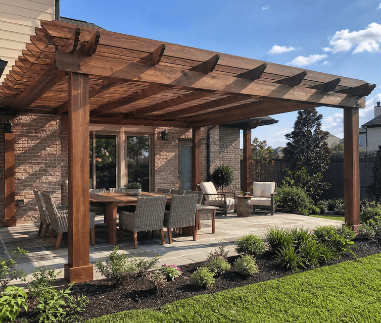 Custom wood pergola shading a finished backyard patio with clean landscaping in Houston