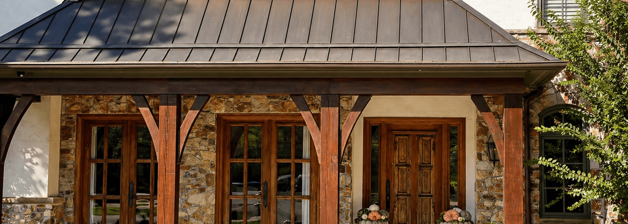 Timber front porch framed by manicured boxwood hedges and flower beds landscaped by Strong Landscaping